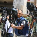 Journalists filming a live broadcast outdoors in Gaza Strip.
